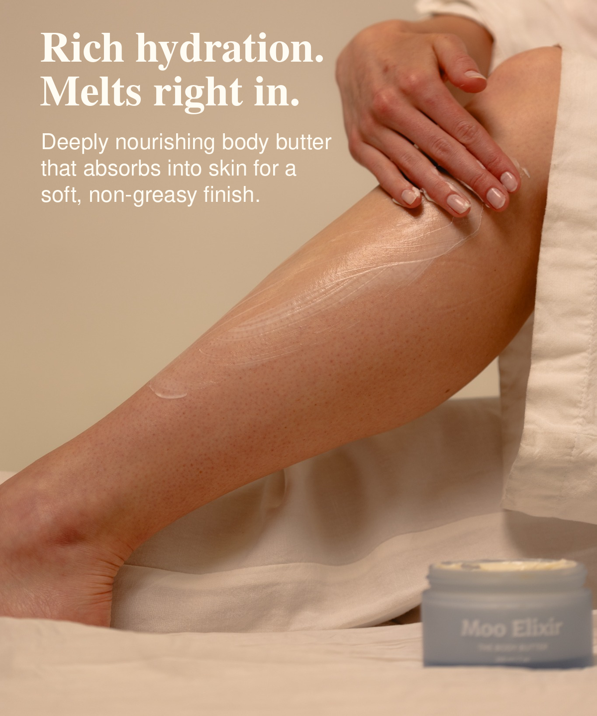 Person massaging Moo Elixir Body Butter onto their leg, with an open jar beside them. Text reads: “Rich hydration. Melts right in. Deeply nourishing body butter that absorbs into skin for a soft, non-greasy finish.”