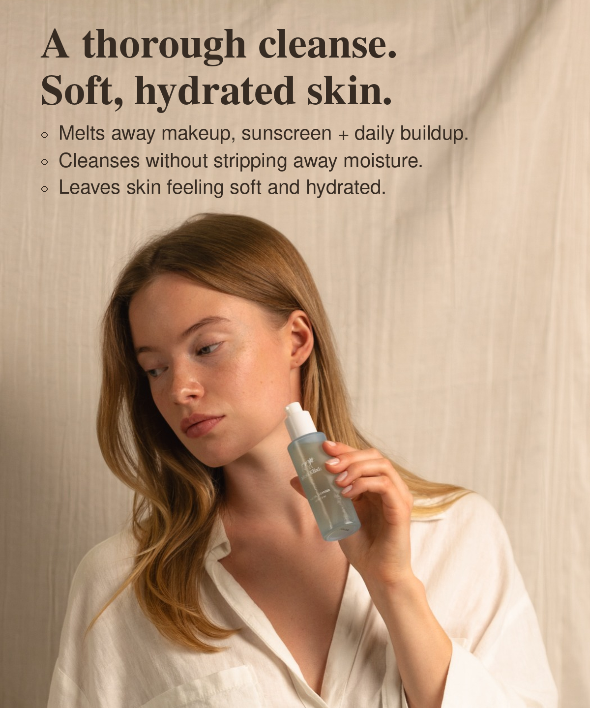 Woman in a white shirt holding Moo Elixir Oil Cleanser. Text reads: “A clean start. The Oil Cleanser benefits: Deeply nourishing. Dissolves makeup and impurities. Soft, balanced, comfortable skin. Cleanses without stripping. Nutrient-rich care.”